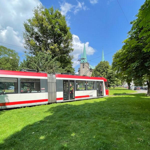 Straßenbahn quert Grünfläche am Berliner Platz
